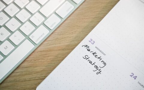 Close-up of a desk with a keyboard and a calendar open to a marketing strategy note.